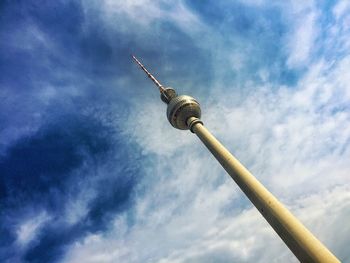 Low angle view of fernsehturm against cloudy sky