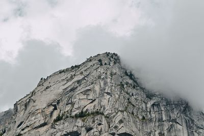 Low angle view of rocky mountain against sky