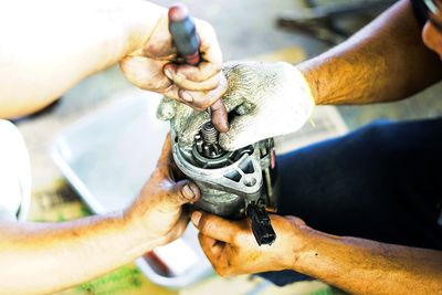 Close-up of man working on bicycle