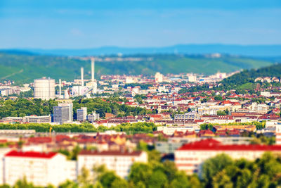 Tilt-shift shot of buildings in city against sky