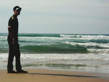 Man standing on beach against sky