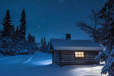 Illuminated log house at night