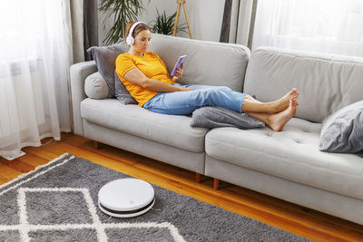 Young woman sitting on sofa at home