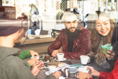 Friends having coffee at table in cafe