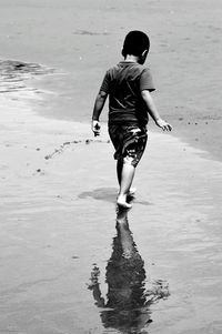 Rear view of boy walking on beach