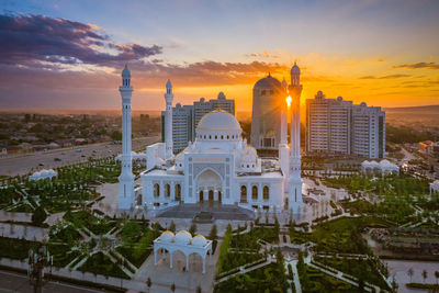 Mosque. buildings in city against sky during sunset.