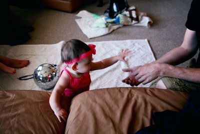 Woman holding hands while sitting on floor