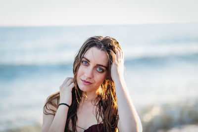 Portrait of smiling young woman against sea