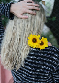 Close-up of woman with yellow flower