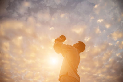 Low angle view of man holding orange sky