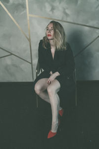 Young woman sitting on wall