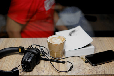 Desk table in coffee shop with headphones ,book and coffee