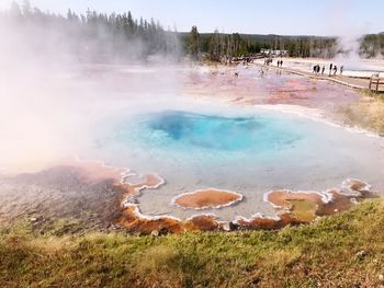 Panoramic view of people walking on landscape against sky