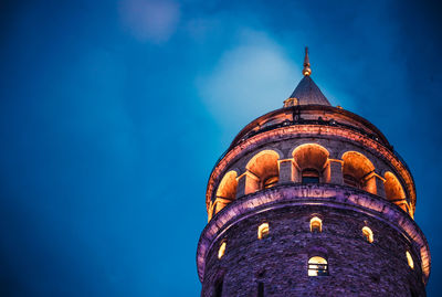 Low angle view of illuminated building against blue sky