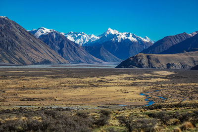 Scenic view of snowcapped mountains against blue sky