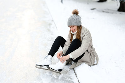 Portrait of young woman sitting on snow