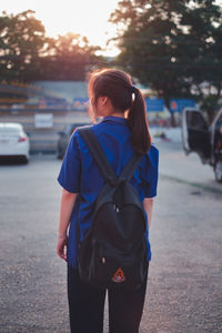 Rear view of woman standing on street in city