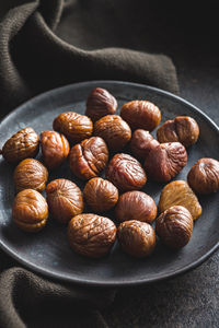 Close-up of roasted coffee beans in plate on table