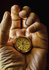 Cropped hand holding clock