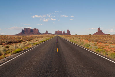 Scenic view of empty road leading to rock formations