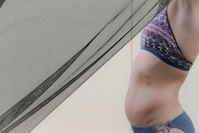 Midsection of woman standing against wall