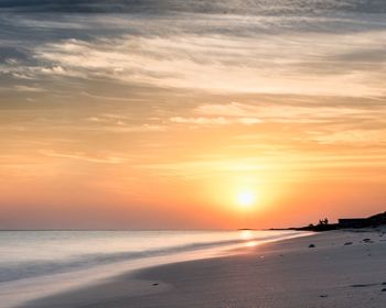 Scenic view of beach against sky during sunset