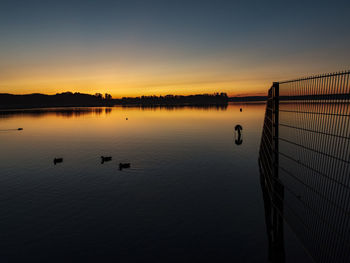 Scenic view of lake against sky during sunset