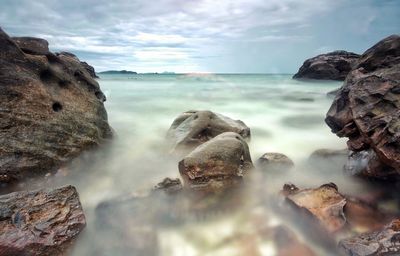 Close-up of rocks on beach against sky