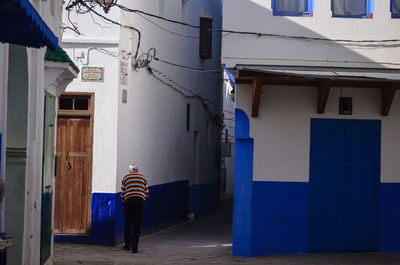 Rear view of man standing by building