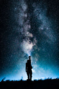 Silhouette man standing against star field at night