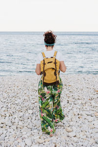 Rear view of woman standing on beach