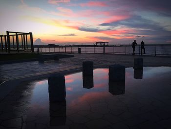 Pier on sea at sunset