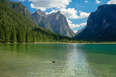 Scenic view of lake by mountains against sky