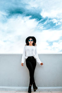 Full length of woman standing against wall