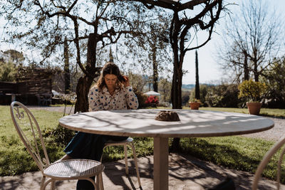 Rear view of woman sitting on table