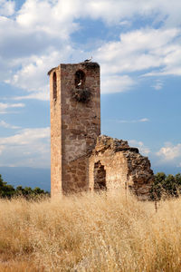 Old ruins on field against sky