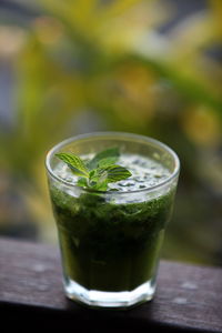 Close-up of smoothie garnish with mint leaves on railing