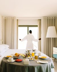 Rear view of man standing on table