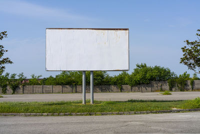 A large blank billboard on a city street parking lot