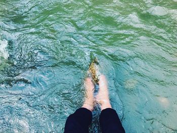 Low section of woman standing in sea