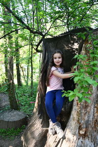 Full length of girl sitting in hollow tree