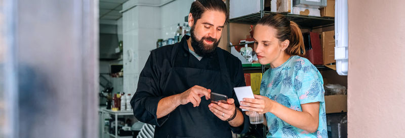 Cook showing mobile to waitress during work break