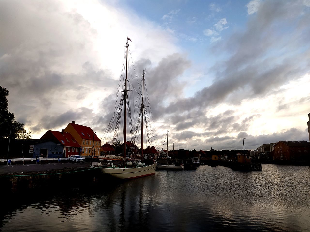 water, sky, cloud, reflection, architecture, evening, nautical vessel, dusk, transportation, sunset, nature, built structure, mode of transportation, sea, building exterior, sailboat, harbor, cityscape, no people, ship, city, travel destinations, boat, building, vehicle, beauty in nature, dock, outdoors, travel, waterway, mast, tranquility, moored, waterfront, pole, house, scenics - nature