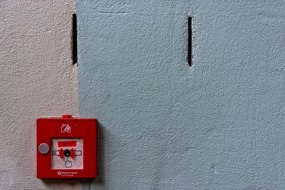 Close-up of red fire alarm on wall