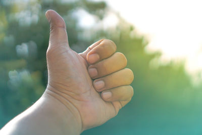 Close-up of man showing thumbs up