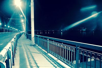 Narrow walkway along illuminated street lights at night