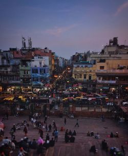 Crowd on illuminated city against sky