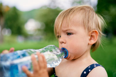 Close-up of cute baby drinking water outdoors