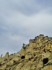 Low angle view of rock formations against sky