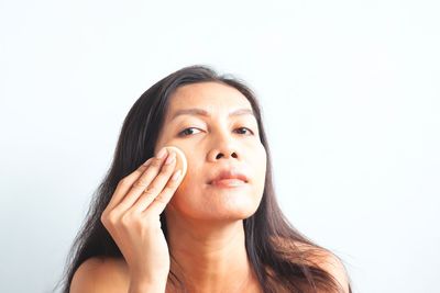 Portrait of young woman against white background